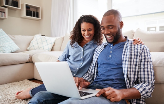 Couple using laptop and smiling